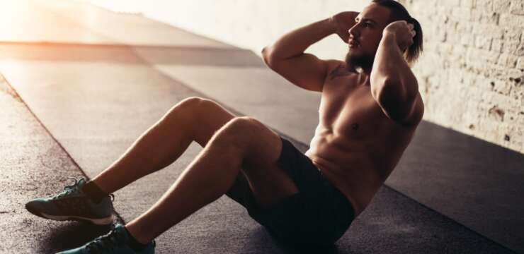 young man doing sit ups on floor|