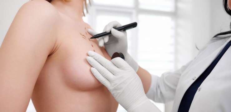 doctor drawing on womans chest